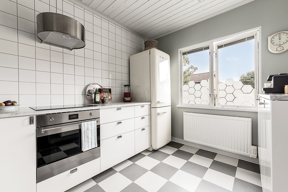 Tidstypiskt kök med helkaklade väggar, marmorskiva mm 